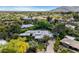 Aerial view of property showcasing lush landscaping, pool, and surrounding neighborhood with mountain views at 9829 N 49Th Pl, Paradise Valley, AZ 85253