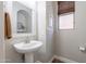 Powder bathroom features pedestal sink, mirror and window with neutral color palette at 10234 E Lomita Ave, Mesa, AZ 85209