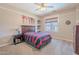Comfortable bedroom features carpet, ceiling fan, and large window overlooking neighborhood at 10234 E Lomita Ave, Mesa, AZ 85209