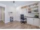 Bright office features built in shelving and cabinets, desk area and wood look floors at 10234 E Lomita Ave, Mesa, AZ 85209