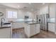 Modern kitchen with white cabinets, stainless steel appliances, and an island with dark countertops at 10234 E Lomita Ave, Mesa, AZ 85209