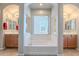 Bright main bathroom with dual vanities and soaking tub with a window at 10234 E Lomita Ave, Mesa, AZ 85209
