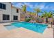 A backyard pool with palms, a waterfall feature, and basketball hoop, set against a sunny sky at 10234 E Lomita Ave, Mesa, AZ 85209