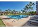 Resort-style pool with a sundeck, lounge chairs, palm trees, and cabana area under a bright blue sky at 1040 E Osborn Rd # 1103, Phoenix, AZ 85014
