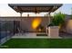 Cozy covered patio with a built-in BBQ, outdoor seating, and manicured desert landscaping at 10850 W Bronco Trl, Peoria, AZ 85383