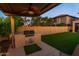 Outdoor kitchen and covered patio with lush green turf make this backyard perfect for entertaining and relaxing at 10850 W Bronco Trl, Peoria, AZ 85383