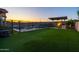 Beautiful backyard with a fenced pool, spa, built-in BBQ, covered patio and artificial grass at 10850 W Bronco Trl, Peoria, AZ 85383