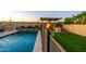 Backyard oasis with a sparkling pool, custom BBQ area, covered patio, and lush landscaping at 10850 W Bronco Trl, Peoria, AZ 85383