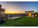 Outdoor haven featuring a pool, spa, covered patio, built-in BBQ, and artificial grass lawn at 10850 W Bronco Trl, Peoria, AZ 85383