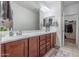Bathroom vanity featuring double sinks, wood cabinets, decorative accents, and tiled flooring at 10850 W Bronco Trl, Peoria, AZ 85383