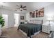 This well-lit bedroom features neutral carpet, a ceiling fan, and access to an ensuite bathroom at 10850 W Bronco Trl, Peoria, AZ 85383