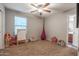 Spacious bedroom with a ceiling fan, a window, and playful decor for children at 10850 W Bronco Trl, Peoria, AZ 85383