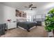 This cozy bedroom features a queen-size bed, neutral carpet, a ceiling fan, and a comfortable sitting area at 10850 W Bronco Trl, Peoria, AZ 85383