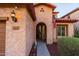Inviting front porch with desert landscaping and charming details around the front door and light fixture at 10850 W Bronco Trl, Peoria, AZ 85383