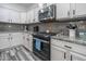 Modern kitchen features granite countertops, gray backsplash, stainless steel appliances, and stylish gray and white cabinets at 10850 W Bronco Trl, Peoria, AZ 85383