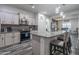 Kitchen island with bar stool seating, granite countertops, modern lighting, and stainless steel appliances at 10850 W Bronco Trl, Peoria, AZ 85383