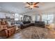 Open-concept living room with a spacious seating area, ceiling fan, and views into kitchen and dining area at 10850 W Bronco Trl, Peoria, AZ 85383