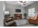 Cozy living room featuring a fireplace, ceiling fan, and neutral paint that is perfect for relaxing at 10850 W Bronco Trl, Peoria, AZ 85383