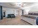 Spacious primary bedroom with a ceiling fan, neutral carpet, and a view into the ensuite bath at 10850 W Bronco Trl, Peoria, AZ 85383
