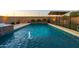 Resort-style pool with shimmering blue water, fountain feature, stone surround, and lush landscaping at 10850 W Bronco Trl, Peoria, AZ 85383
