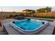 Relaxing hot tub with crystal-clear water, stone surround, and lush landscaping with private setting at 10850 W Bronco Trl, Peoria, AZ 85383