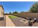 Expansive backyard with well-kept lawn, fire pit area, and privacy fencing, perfect for relaxation at 13811 W Paso Trl, Peoria, AZ 85383