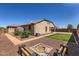 Large private backyard featuring a fire pit area, lush lawn, and thoughtfully designed landscaping at 13811 W Paso Trl, Peoria, AZ 85383