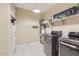 Functional laundry room boasts modern washer and dryer, ample shelving, and stylish decor at 13811 W Paso Trl, Peoria, AZ 85383