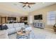 Open-concept living room with tile flooring and ceiling fan, adjacent to modern kitchen at 13811 W Paso Trl, Peoria, AZ 85383