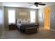 Comfortable primary bedroom features wood-look floors, plush linens, and bright windows at 13811 W Paso Trl, Peoria, AZ 85383