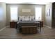 Comfortable primary bedroom features wood-look floors, plush linens, and bright windows at 13811 W Paso Trl, Peoria, AZ 85383