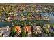 Expansive aerial view of a lakefront community with tile-roofed houses and mature palm trees at 1507 E Treasure Cove Dr, Gilbert, AZ 85234