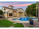Private backyard oasis with pool and spa, landscaped gardens, patio, and charming string lights for evening ambiance at 1507 E Treasure Cove Dr, Gilbert, AZ 85234