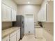 Functional laundry room featuring white cabinetry, granite counters, stainless steel appliances, and modern fixtures at 1507 E Treasure Cove Dr, Gilbert, AZ 85234