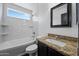 A well lit bathroom features a shower over tub, granite counters and framed mirror at 16044 S 41St Pl, Phoenix, AZ 85048
