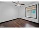 A bedroom featuring a ceiling fan, dark wood floors, and a window with blinds at 16044 S 41St Pl, Phoenix, AZ 85048