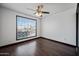 A bedroom featuring a large window, ceiling fan, and dark wood floors at 16044 S 41St Pl, Phoenix, AZ 85048