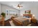 Bright bedroom with a bay window, ceiling fan, and wood furniture at 17418 N Carmen Ave, Maricopa, AZ 85139