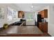 This kitchen features wood cabinetry, dark countertops, dual basin sink, and modern appliances at 17418 N Carmen Ave, Maricopa, AZ 85139