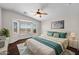 Bright main bedroom with large windows, a ceiling fan, and a comfortable bed with stylish decor at 17418 N Carmen Ave, Maricopa, AZ 85139