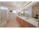 Bright bathroom featuring a dual sink vanity, large mirror, and shower tub combination at 1750 W Union Hills Dr # 8, Phoenix, AZ 85027