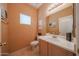 Compact powder room with vanity, square mirror, and natural light at 1750 W Union Hills Dr # 8, Phoenix, AZ 85027