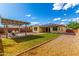This backyard features an artificial lawn, gravel, and a pergola with outdoor seating at 18417 W Elm St, Goodyear, AZ 85395