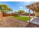 This backyard features an artificial lawn, gravel, and a pergola with outdoor seating at 18417 W Elm St, Goodyear, AZ 85395