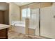 Bathroom featuring a soaking tub and a separate shower with glass doors at 18417 W Elm St, Goodyear, AZ 85395