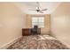 This carpeted bedroom features a ceiling fan, neutral walls, and a desk at 18417 W Elm St, Goodyear, AZ 85395