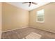 An empty bedroom featuring carpet and a large window at 18417 W Elm St, Goodyear, AZ 85395