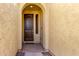 Arched entry featuring a solid wood door with textured walls and stylish stone accents at 18417 W Elm St, Goodyear, AZ 85395