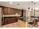A gourmet kitchen features dark cabinetry, granite countertops and stainless steel appliances at 18417 W Elm St, Goodyear, AZ 85395