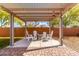 Covered patio area featuring a fire pit and seating, ideal for relaxing evenings outdoors in a private setting at 18417 W Elm St, Goodyear, AZ 85395